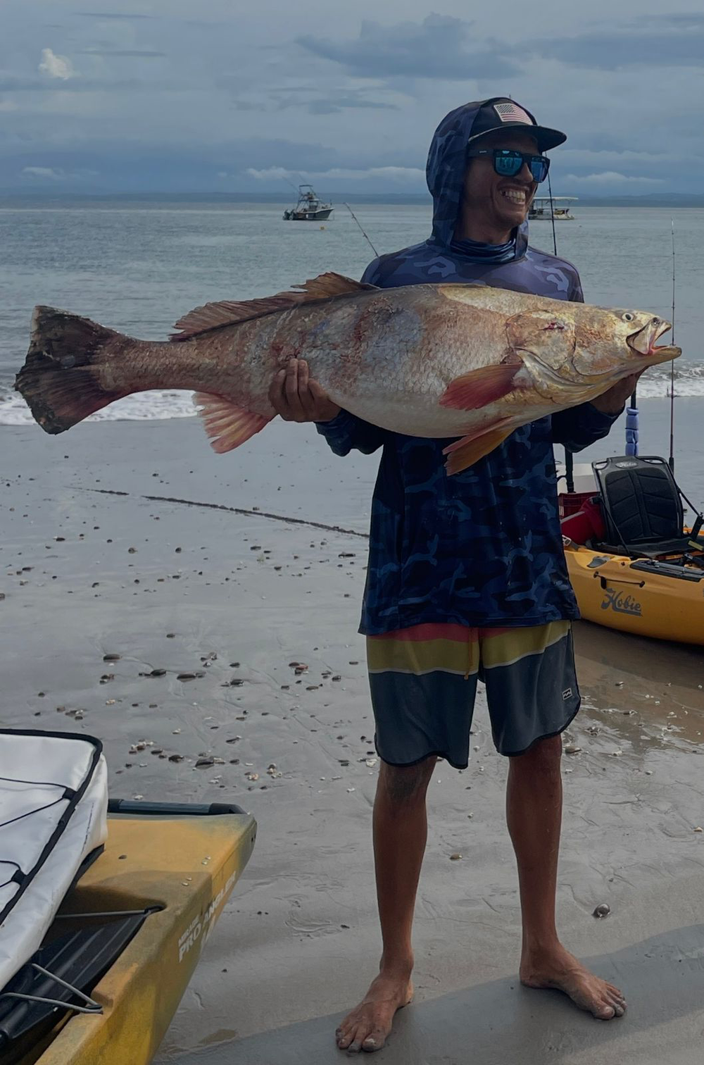 Saltwater angler standing on the beach with an enormous catch